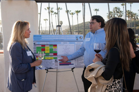UCI grad student Jacob Samson (right) presents his solution to attendees of the Resilient Shores reception in San Clemente.