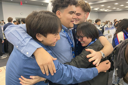 Team members from Project Prometheus, a wildfire detection system, go all in for a group hug after winning a Dean’s Choice Award. 