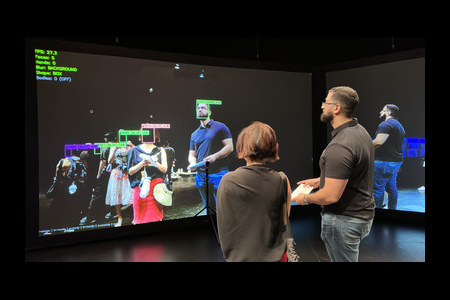 Ph.D. graduate Jad Al Aaraj (right) demonstrates technology he created that enables people to opt out of visual tracking by public cameras.